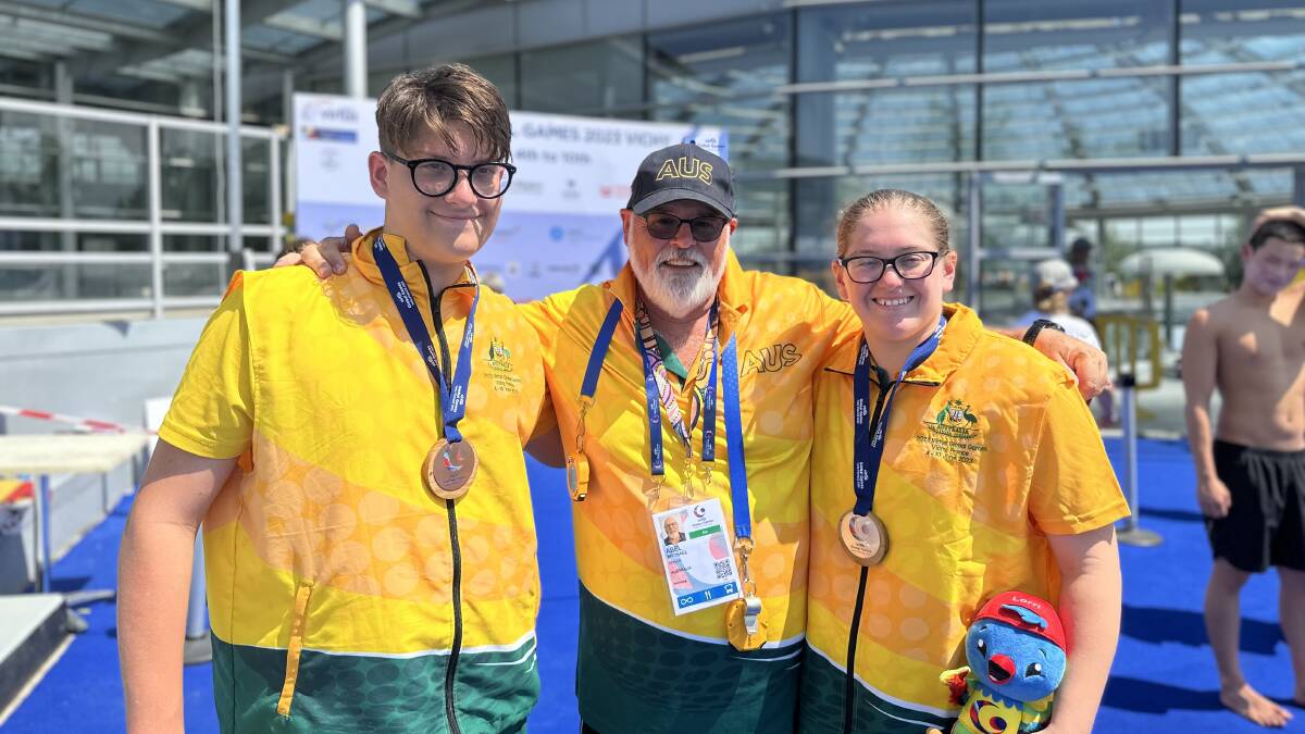 Isaac and Gabby with an Australian swim team coach. Picture supplied.