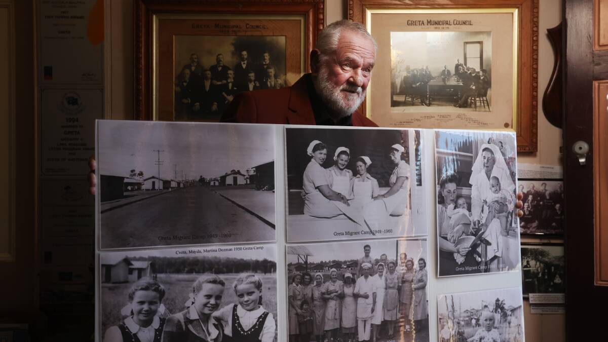 Author and former Greta Migrant Camp resident Alek Schulha at Greta Museum with some historic photos from the camp. Picture by Simone De Peak