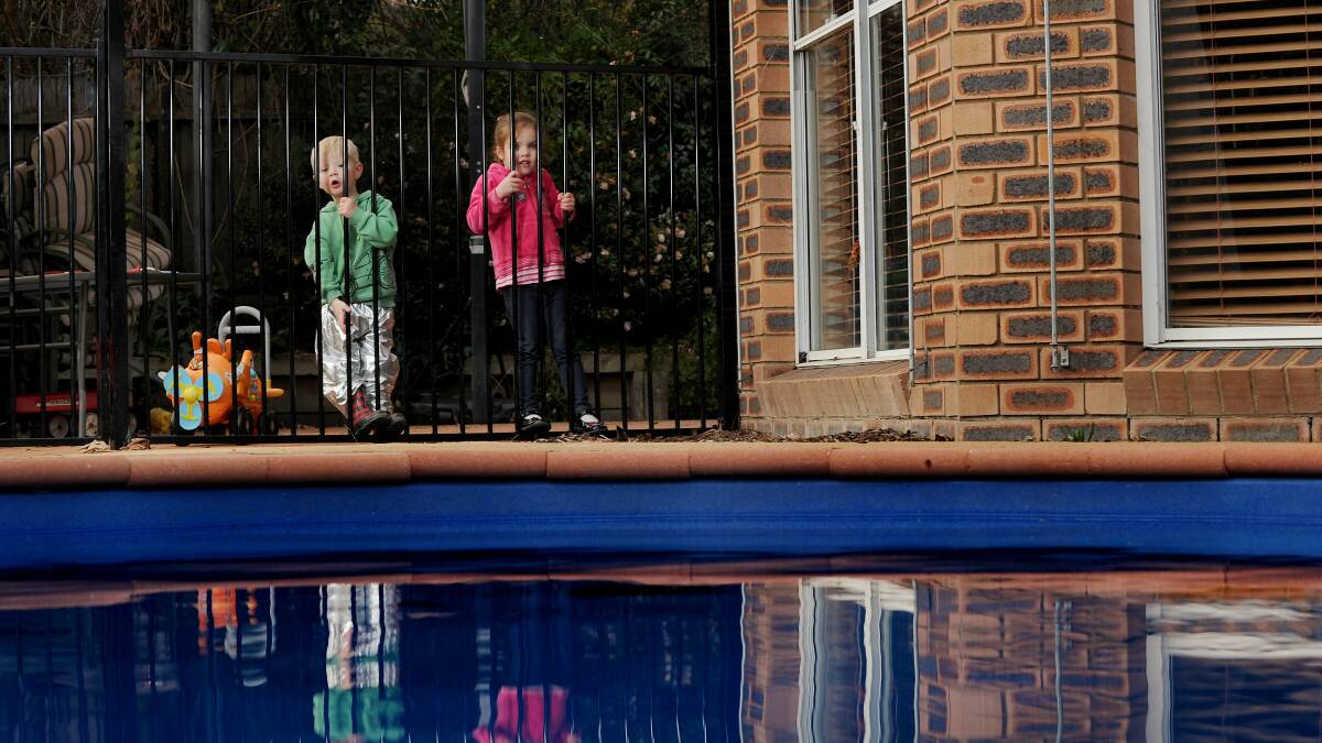 Children stand by the fence of a backyard swimming pool. File picture by Colleen Petch