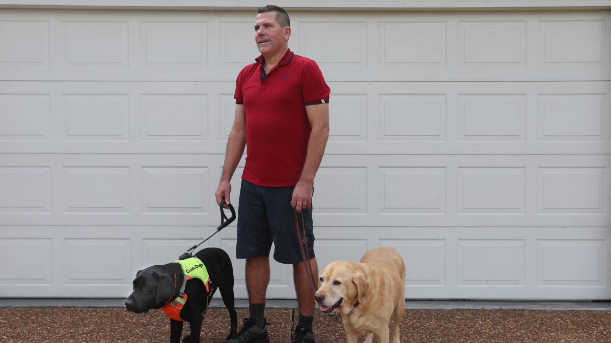 Paul Johns with retired guide dog Keith (right) and his current guide dog Tate (left). Picture by Simone De Peak
