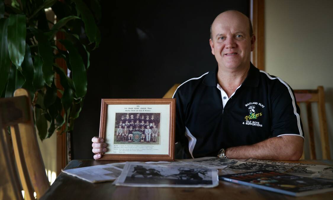 REUNION: Geoff McMahon with a photograph of the 1976 Maitland Boys High School team which won the Buckley Shield. Picture: MARINA NEIL.