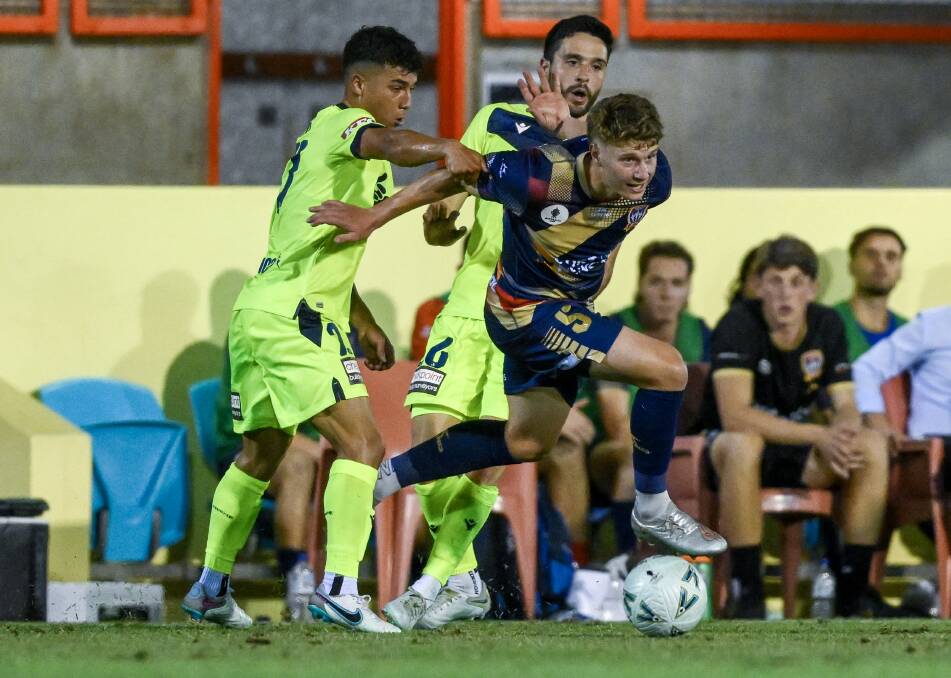 Lucas Mauragis bursts past two defenders in the Newcastle Jets' win over Melbourne Victory on penalties in the Australian Cup qualifier in Darwin on Monday night. Picture Getty Images 