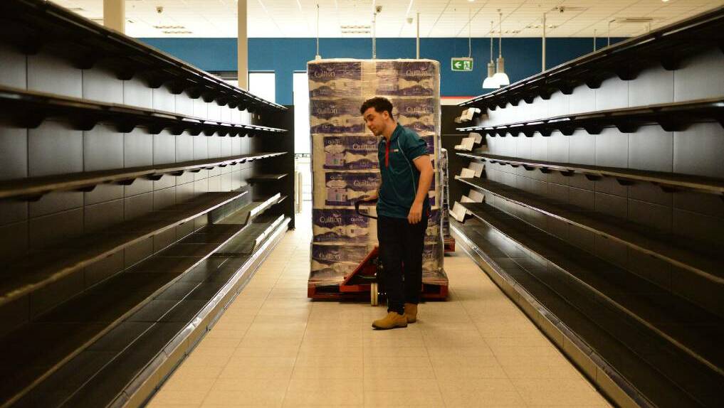 ALMOST READY: Maxi Save staff member Harrison Kantarias stacking the shelves ahead of the store's opening.