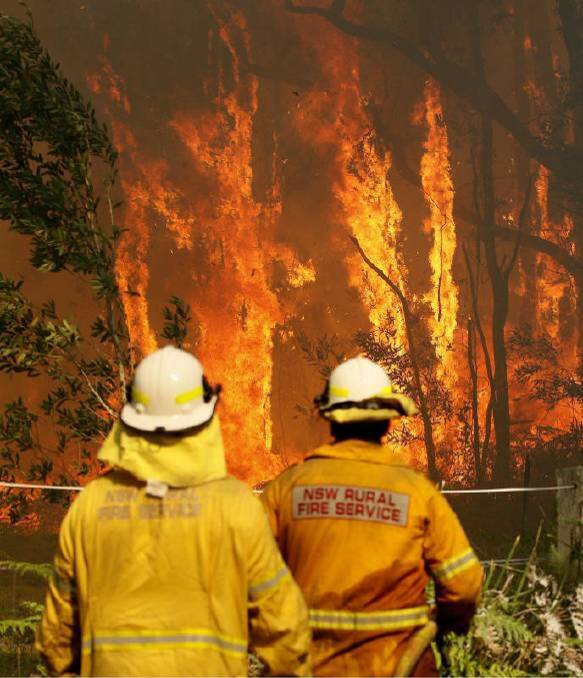 OUT OF CONTROL: Rural Fire crews battle an out of control fire near houses along Lemon Tree Passage Road, in Salt Ash, NSW, Friday. Photo: Darren Pateman.