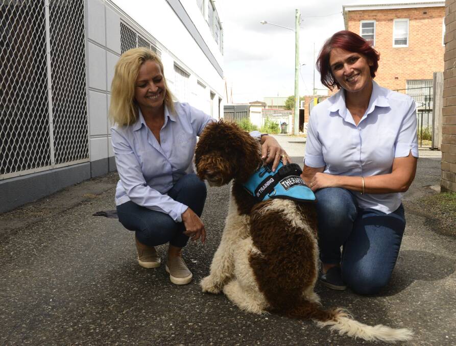 Good boy: Samantha Kay and Kelly Lancaster with Harry the therapy dog. Picture: Lachlan Leeming