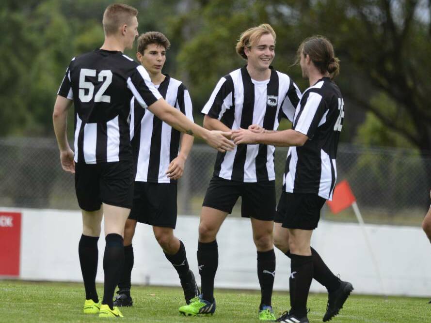 Eagle eye: Magpies players congratulate Chris Hurley, who pumped two goals on Sunday. Picture: Michael Hartshorn 