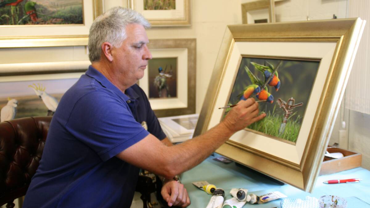 MASTER: James Hough paints the intricate detail and colour on a pair of lorikeets. His work will be for sale at Morpeth this weekend. Picture: supplied
