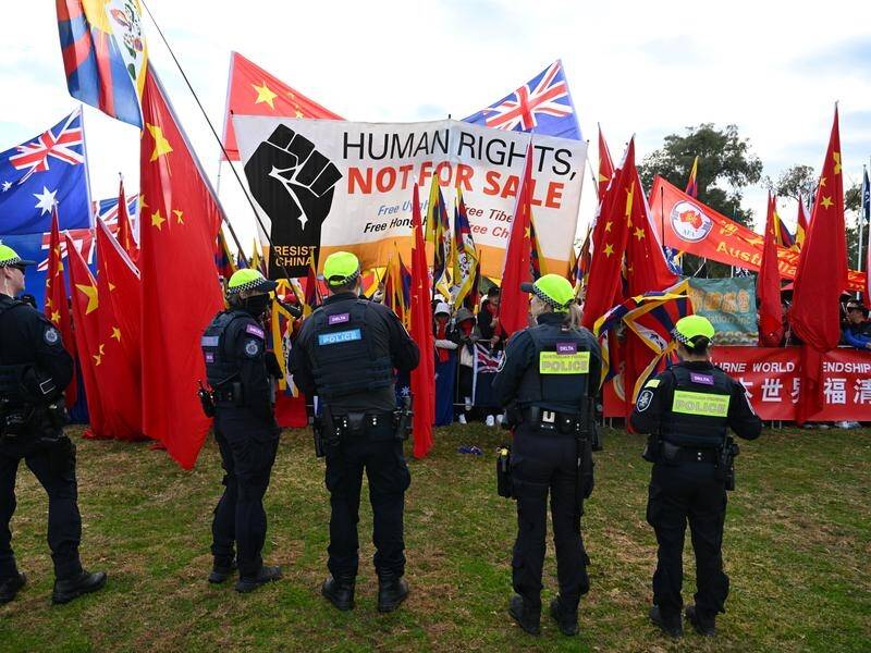 A strong police presence held back passionate pro and anti-China activists outside parliament. (Lukas Coch/AAP PHOTOS)